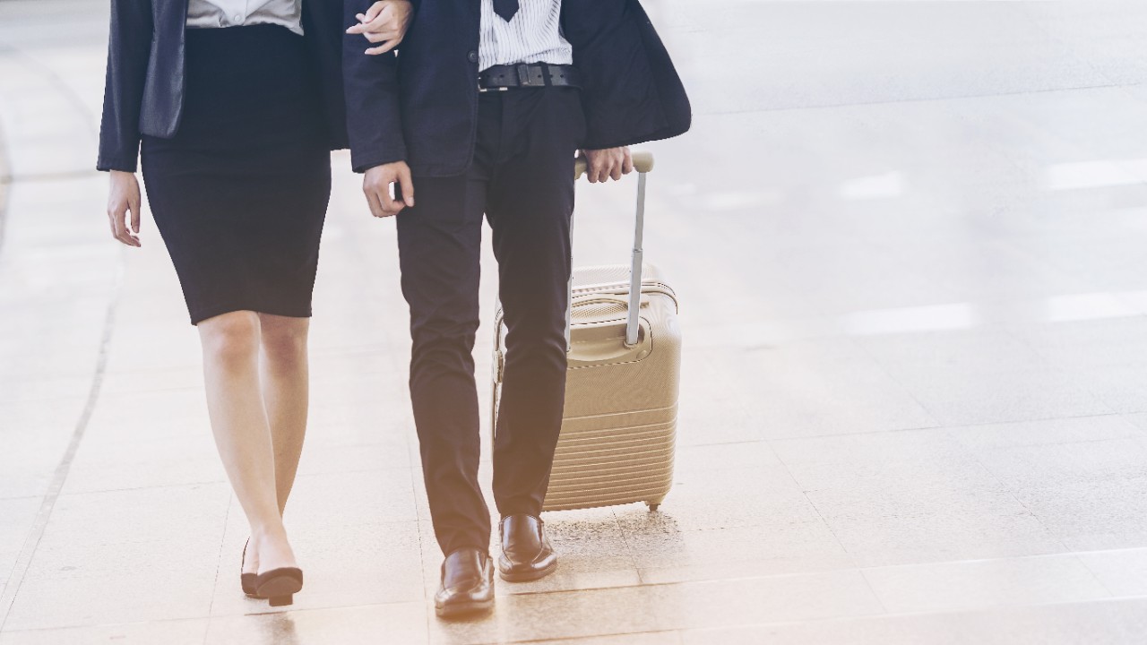 Woman walks with a man carrying a luggage