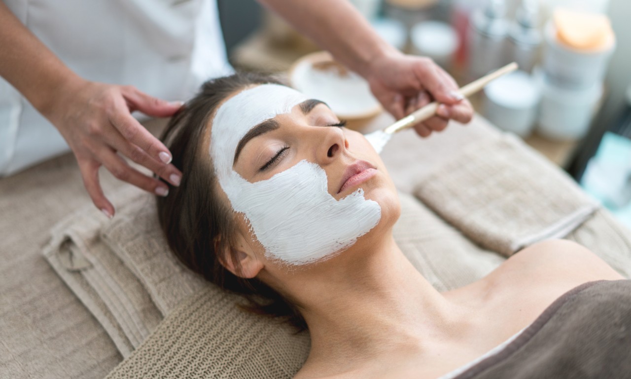 Woman getting a face mask at a spa