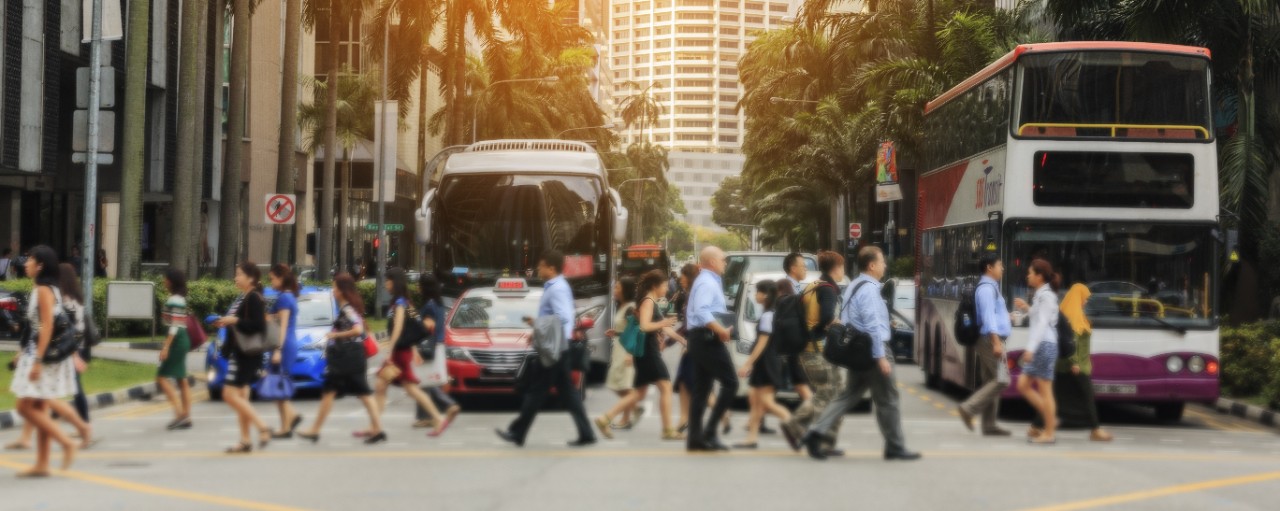 Pedestrians crossing road in Singapore; image used for HSBC Public transport apps you will need in Singapore article page