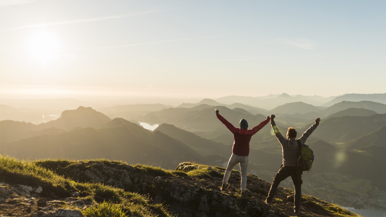 Couple reaching mountain summit; image used for HSBC 8 steps to prepare you for a great retirement article page.