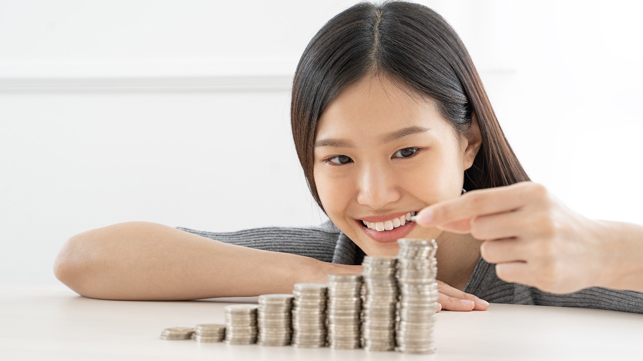 Woman stacking the coins. 